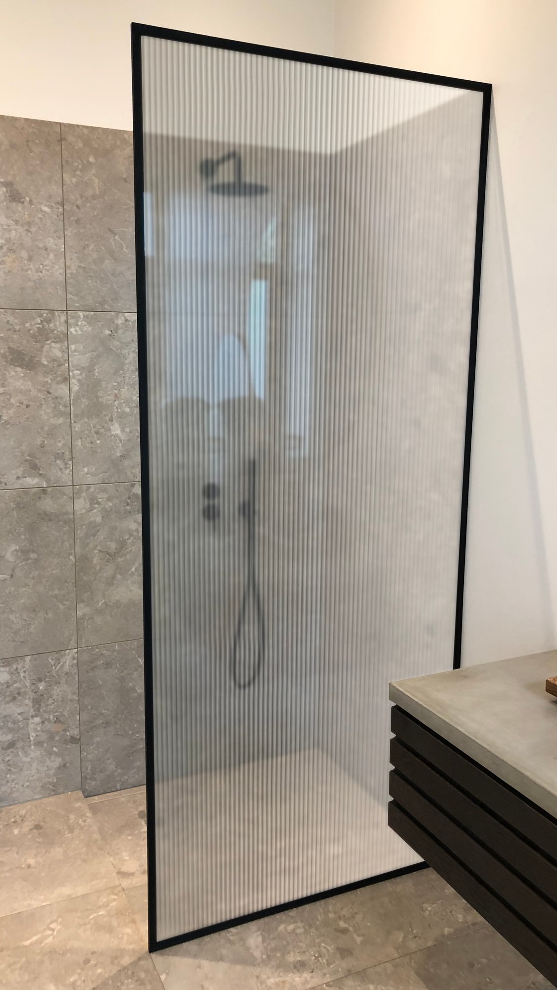 Brusevæg med matsort profilramme og Riflet glas